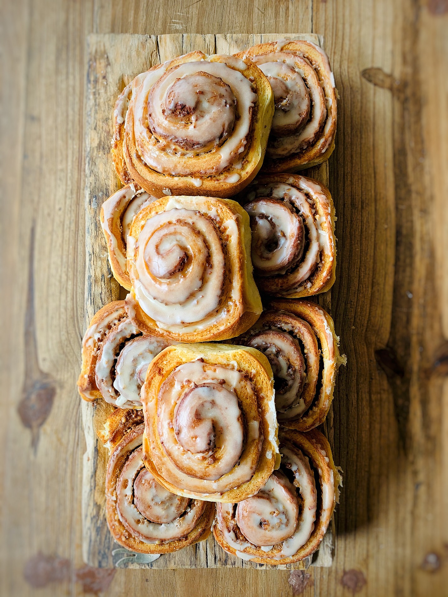Nybakade kanelbullar med glasyr på träskärbräda på Café Grindstugan